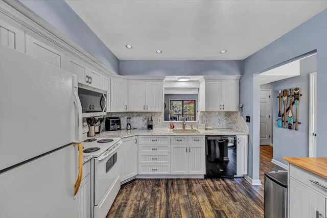 a kitchen with white cabinets stainless steel appliances and sink