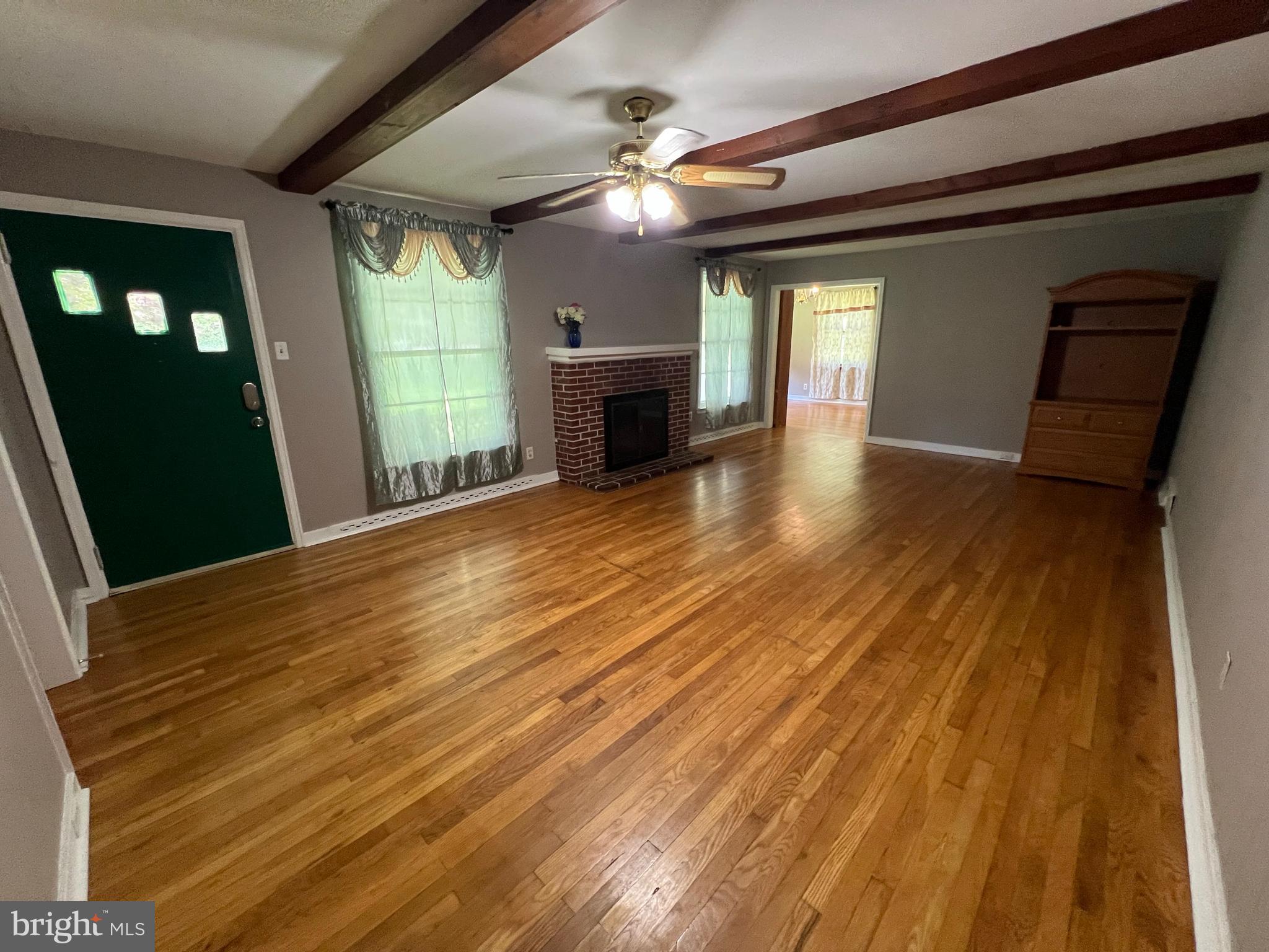 a view of a room with wooden floor and fireplace