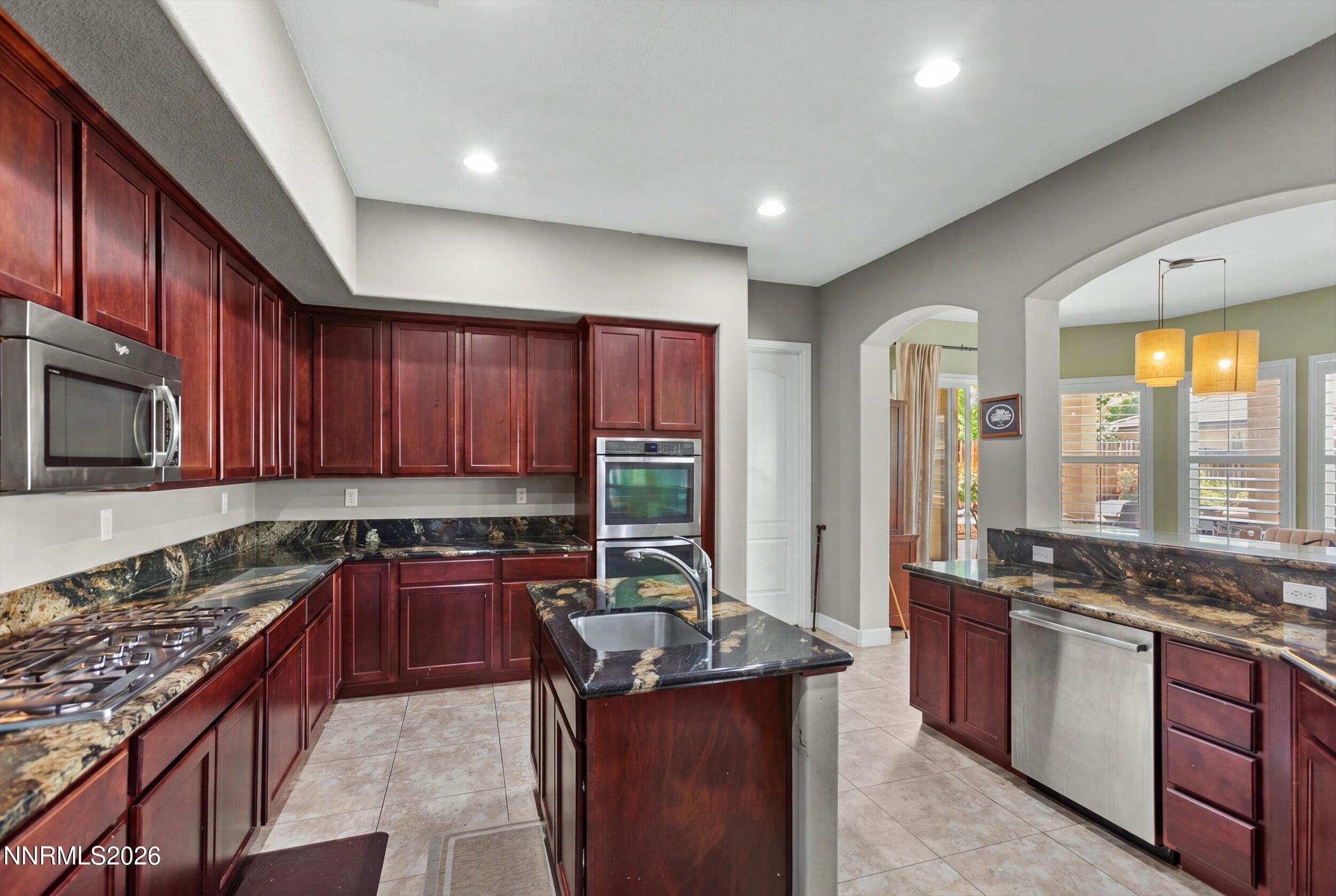 2920 Bull Rider Drive Reno, NV 89521 - Photo 9 of 51 a kitchen with stainless steel appliances granite countertop a stove a sink and a microwave