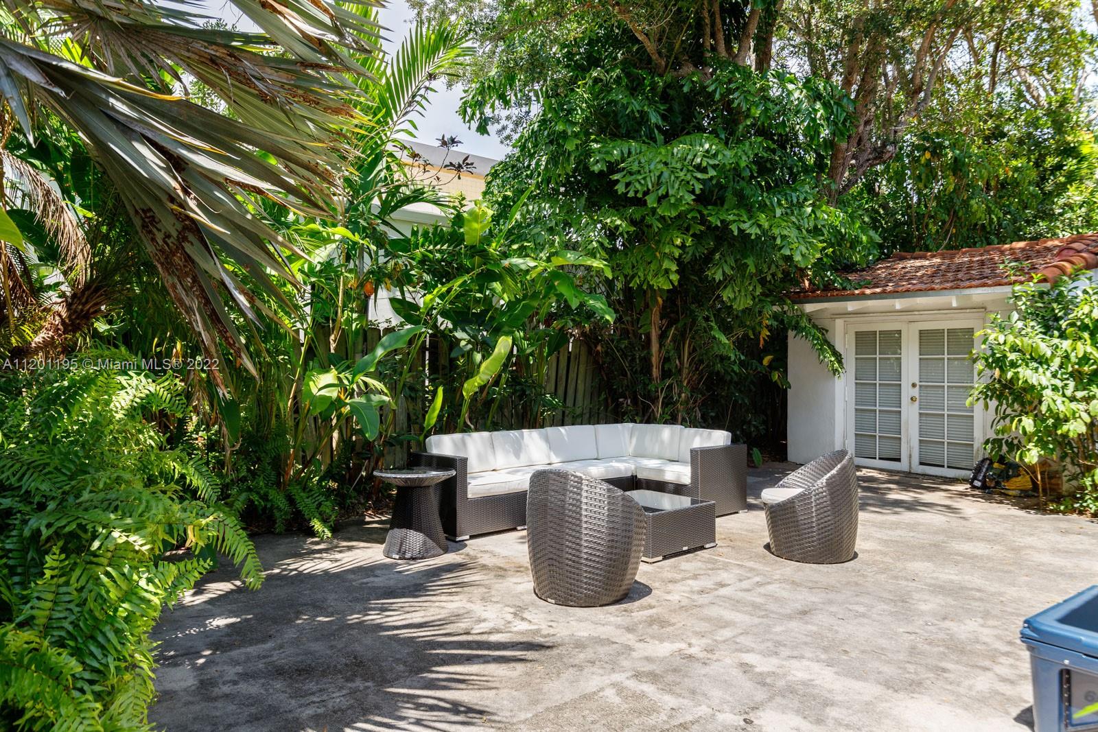 7236 School House Road Miami, FL 33143 - Photo 22 of 25 a view of a patio with table and chairs potted plants and large tree