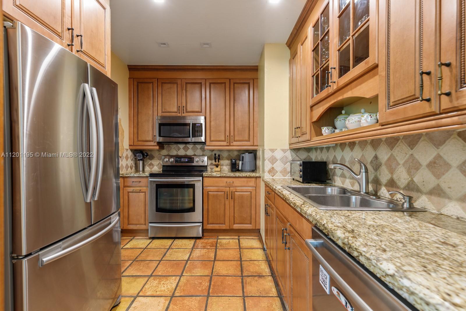 7236 School House Road Miami, FL 33143 - Photo 9 of 25 a kitchen with granite countertop a refrigerator stove and sink