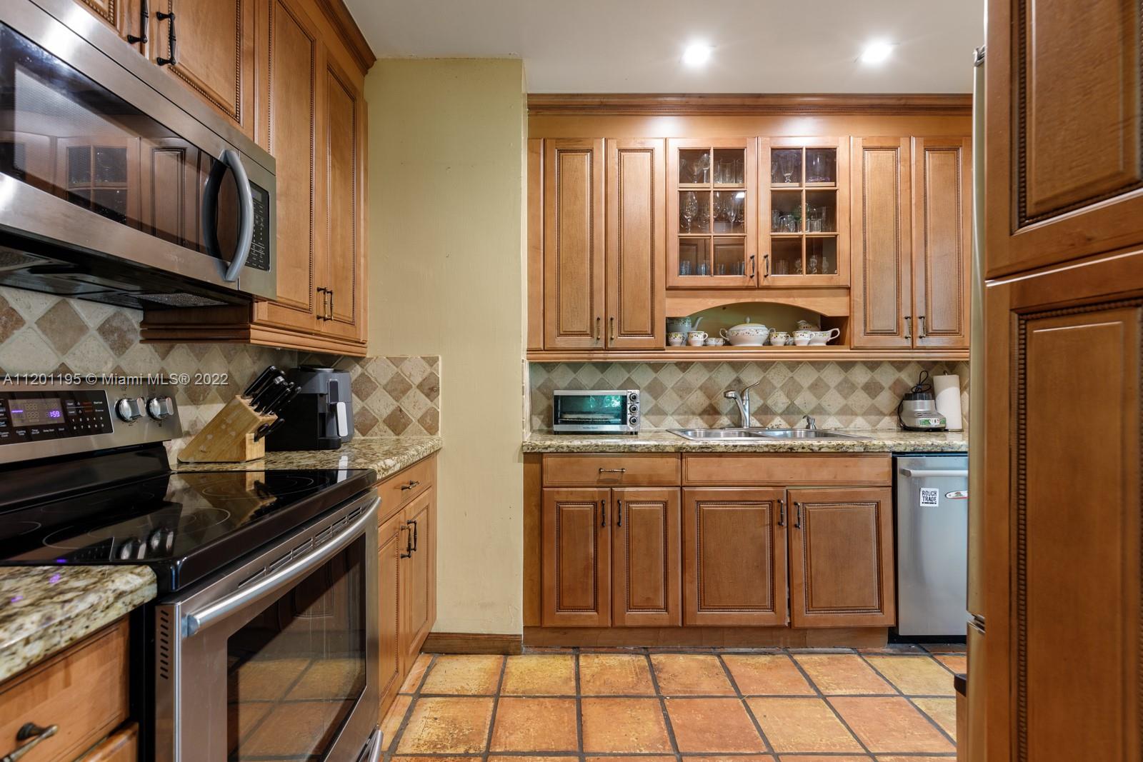 7236 School House Road Miami, FL 33143 - Photo 10 of 25 a kitchen with stainless steel appliances granite countertop a stove and a refrigerator
