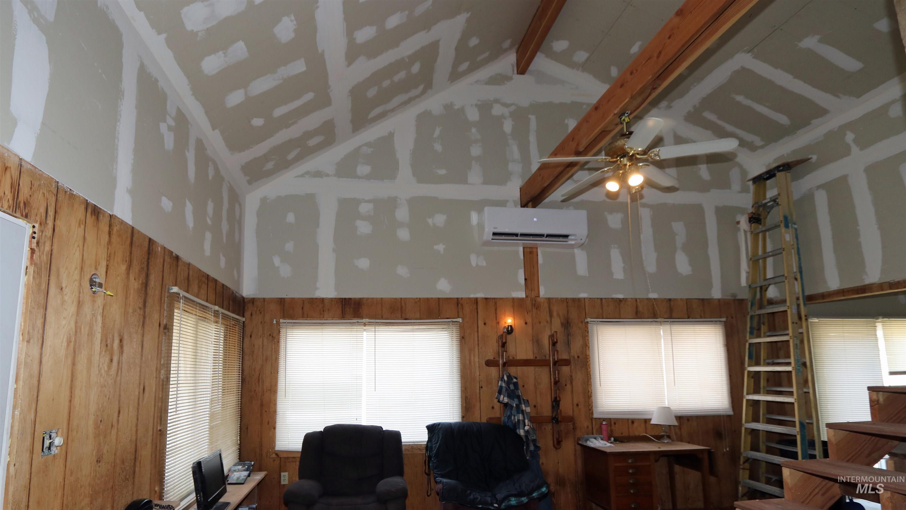1201 Pfi Extension Elk City, ID 83525 - Photo 7 of 50 Living area featuring high vaulted ceiling, a wall unit AC, beamed ceiling, and a ceiling fan