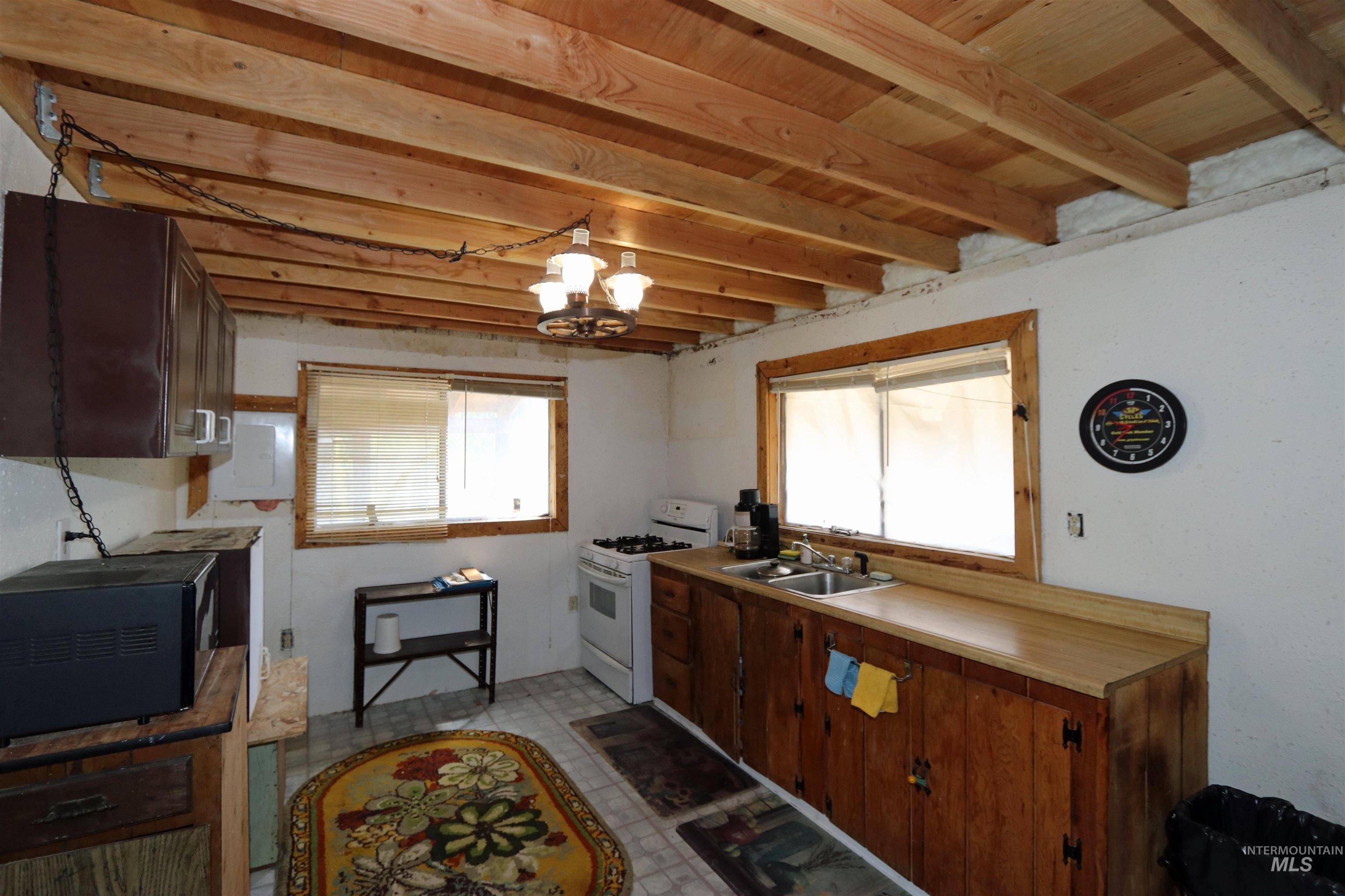 1201 Pfi Extension Elk City, ID 83525 - Photo 9 of 50 Kitchen with white gas stove, light floors, healthy amount of natural light, and black microwave