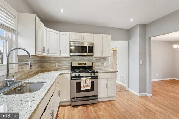 a kitchen with stainless steel appliances granite countertop a refrigerator and a stove