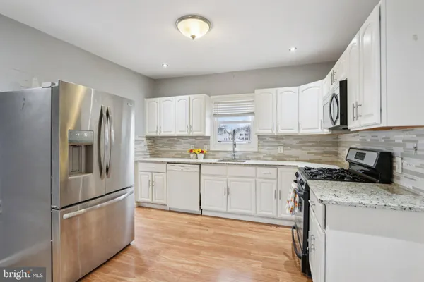 a kitchen with granite countertop a refrigerator and a sink