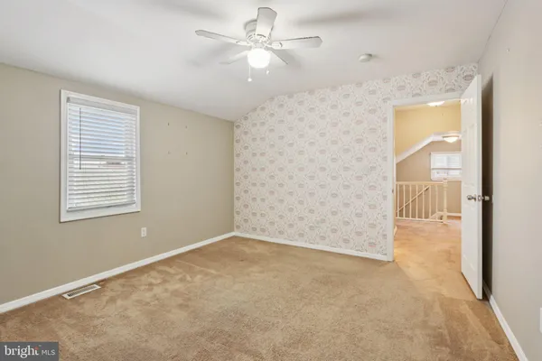 an empty room with window and ceiling fan