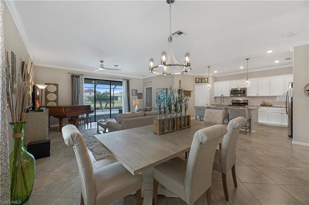 4375 Bismark Way Naples, FL 34119 - Photo 14 of 42 a dining room with stainless steel appliances kitchen island granite countertop a dining table chairs and a refrigerator