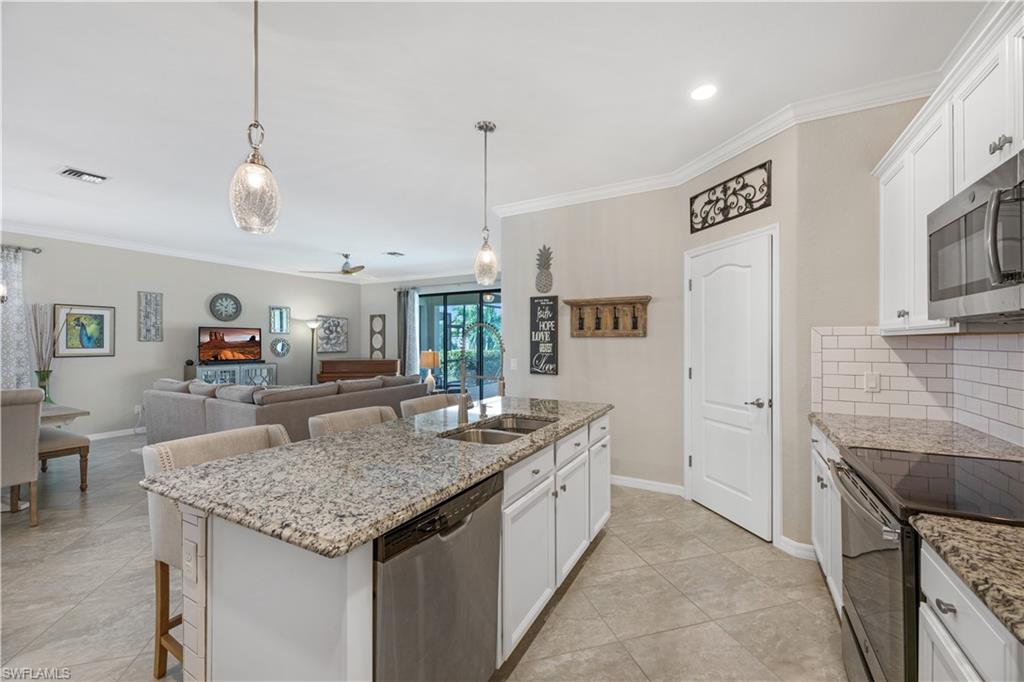 4375 Bismark Way Naples, FL 34119 - Photo 16 of 42 a kitchen with stainless steel appliances granite countertop stove top oven and refrigerator