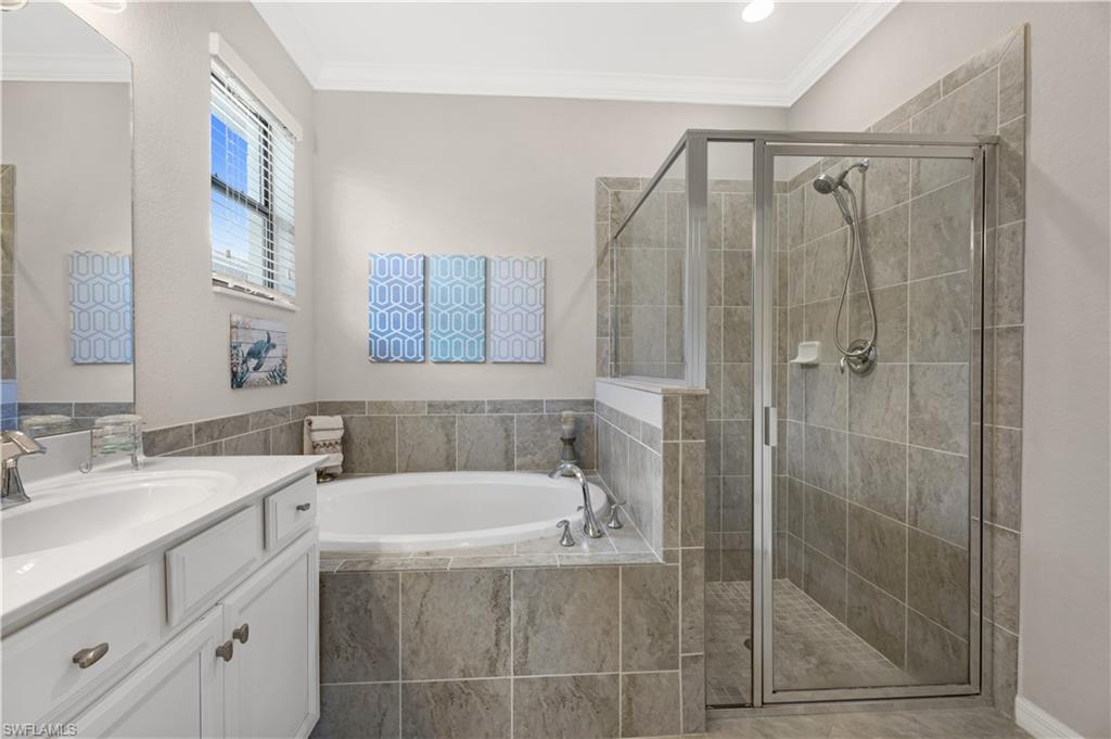 4375 Bismark Way Naples, FL 34119 - Photo 22 of 42 a bathroom with a bathtub a sink a vanity and a shower