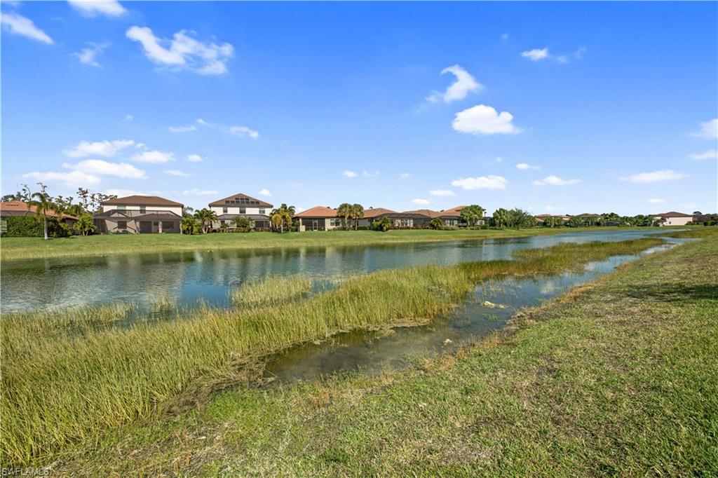 4375 Bismark Way Naples, FL 34119 - Photo 37 of 42 a view of a lake with houses in the back