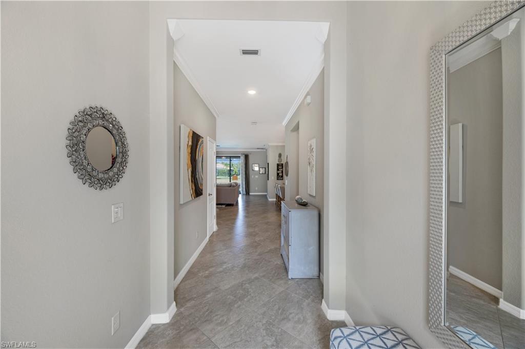 4375 Bismark Way Naples, FL 34119 - Photo 6 of 42 a view of a hallway with wooden floor and a bathroom