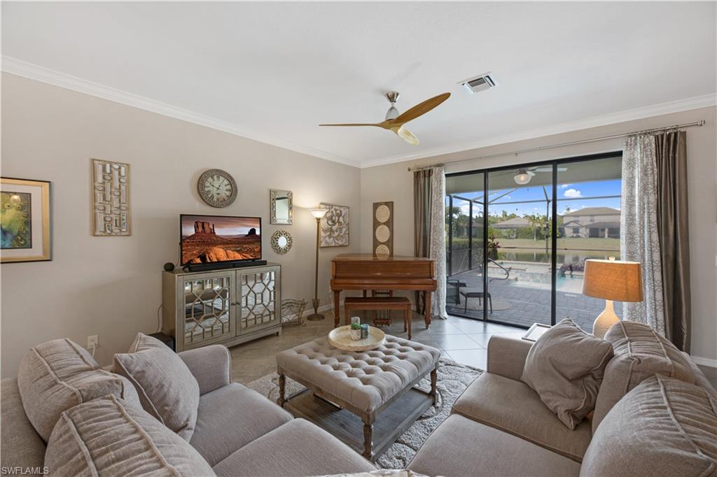 4375 Bismark Way Naples, FL 34119 - Photo 10 of 42 a living room with furniture a flat screen tv and a large window