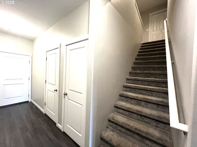 a view of a hallway with wooden floor and entryway