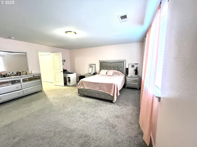 a bed room with a bed and a chair