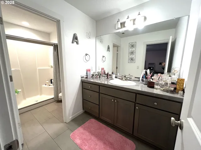 a bathroom with a sink mirror and a shower