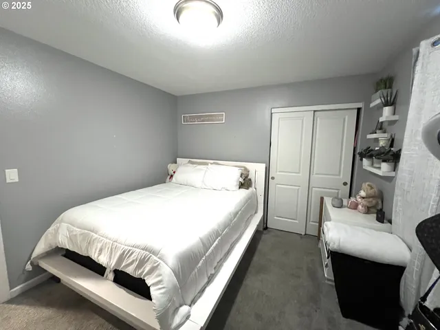 a bed sitting in a bedroom next to a window