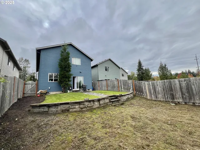 a view of a house with backyard and trees