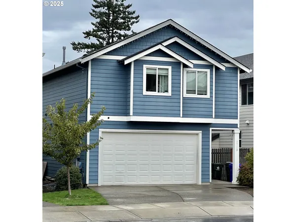 a front view of a house with a yard and garage