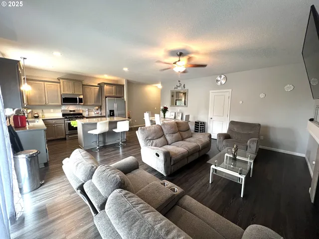 a living room with furniture kitchen and a dining table