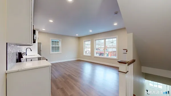 a view of a kitchen with wooden floor and electronic appliances