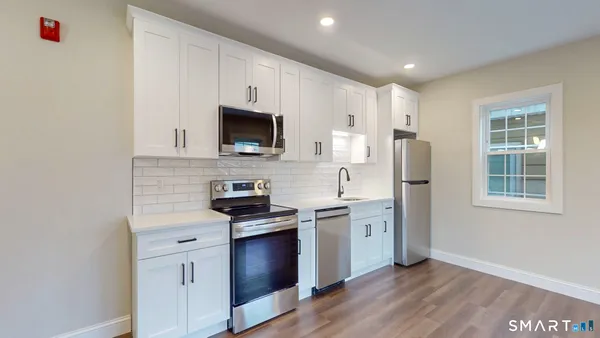 a kitchen with stainless steel appliances a stove a sink dishwasher a refrigerator and a microwave