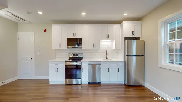 a kitchen with stainless steel appliances granite countertop a refrigerator stove a sink and a microwave