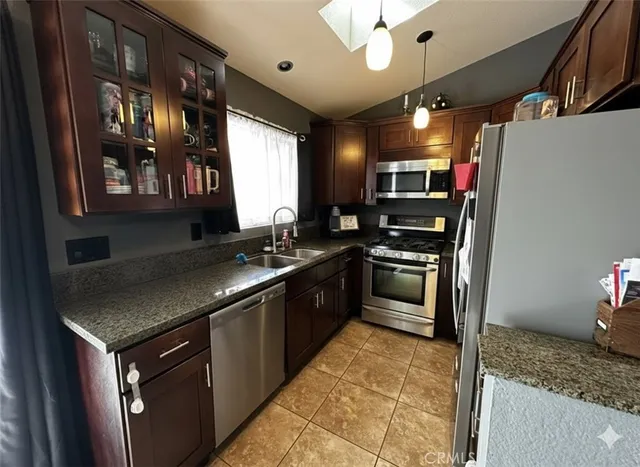a kitchen with stainless steel appliances granite countertop a stove a sink and a refrigerator