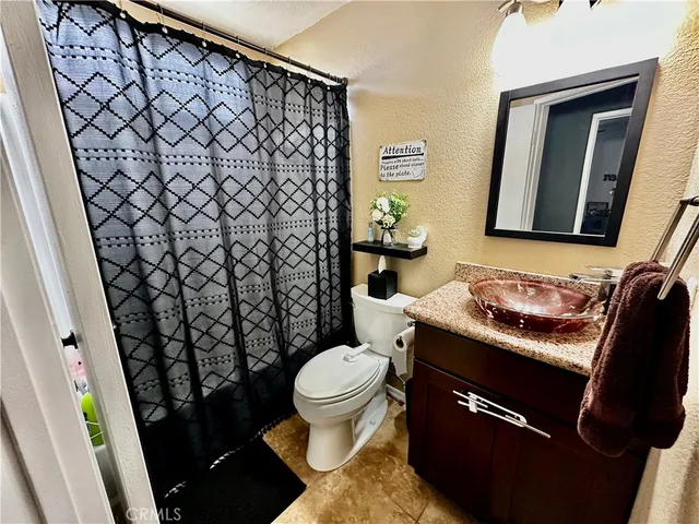 a bathroom with a granite countertop toilet and a sink