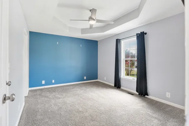 a view of a livingroom with wooden floor and a ceiling fan
