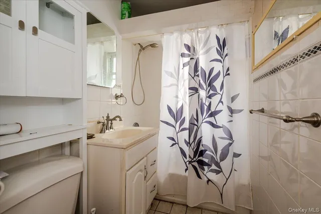 a bathroom with a sink and mirror with bathtub