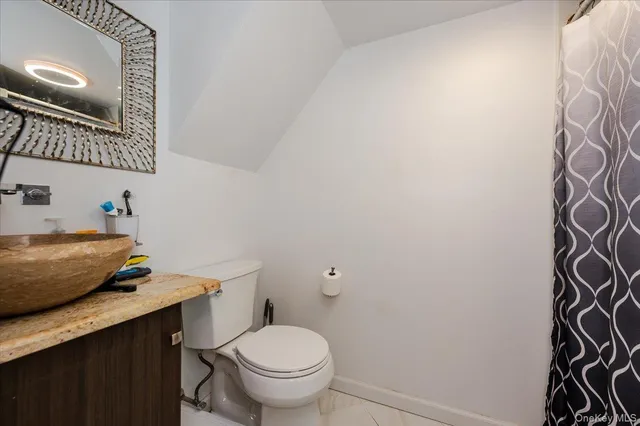 a bathroom with a granite countertop toilet and sink