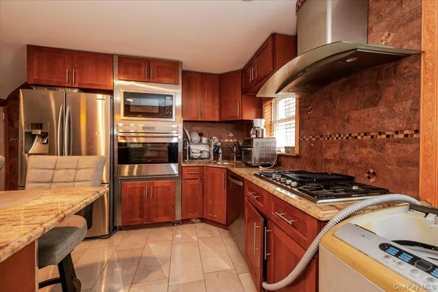 a kitchen with stainless steel appliances granite countertop a stove refrigerator and cabinets