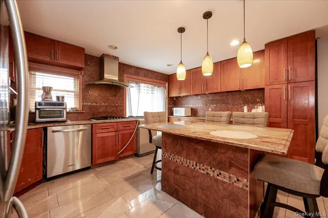 a kitchen with stainless steel appliances granite countertop a sink a stove and a refrigerator