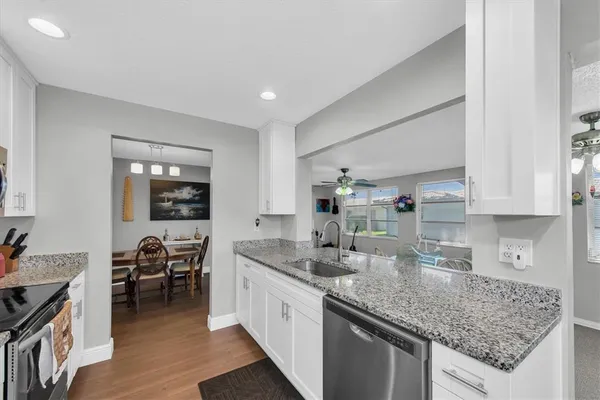 a kitchen with stainless steel appliances granite countertop a sink stove and cabinets
