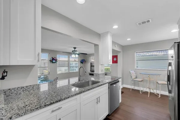 a kitchen with granite countertop a sink and a stove