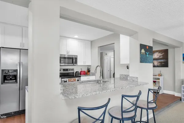 a kitchen with refrigerator and cabinets