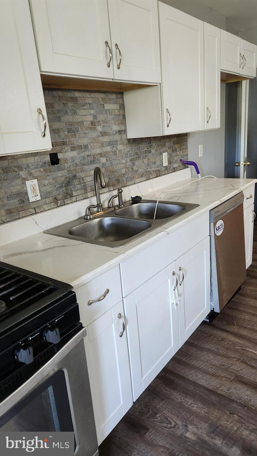 1024 Wicklow Road Baltimore, MD 21229 - Photo 6 of 44 a kitchen with stainless steel appliances a sink dishwasher and white cabinets