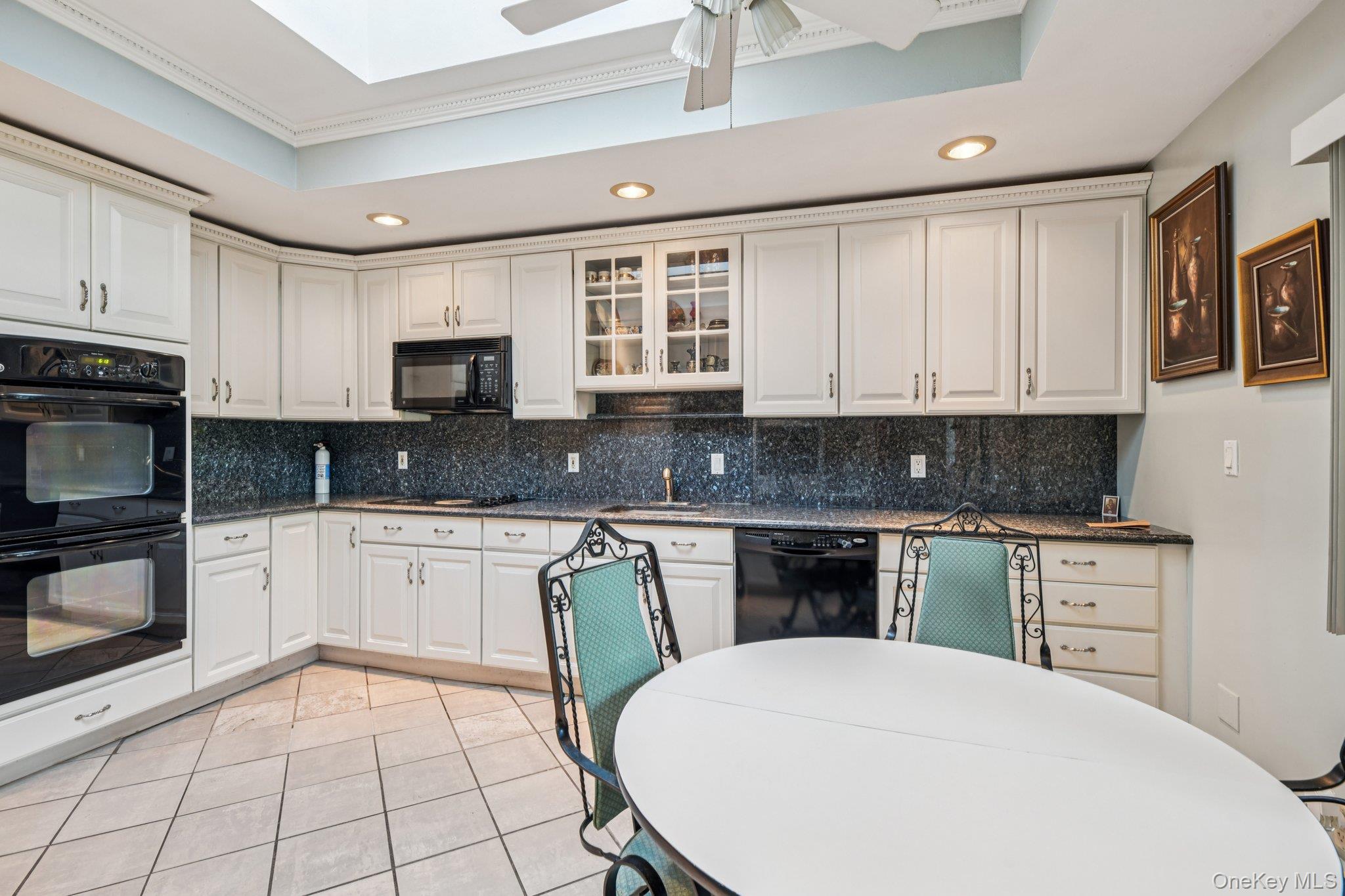 22 Reynolds Road Glen Cove, NY 11542 - Photo 11 of 22 a kitchen with stainless steel appliances granite countertop a stove top oven a sink a microwave and view living room