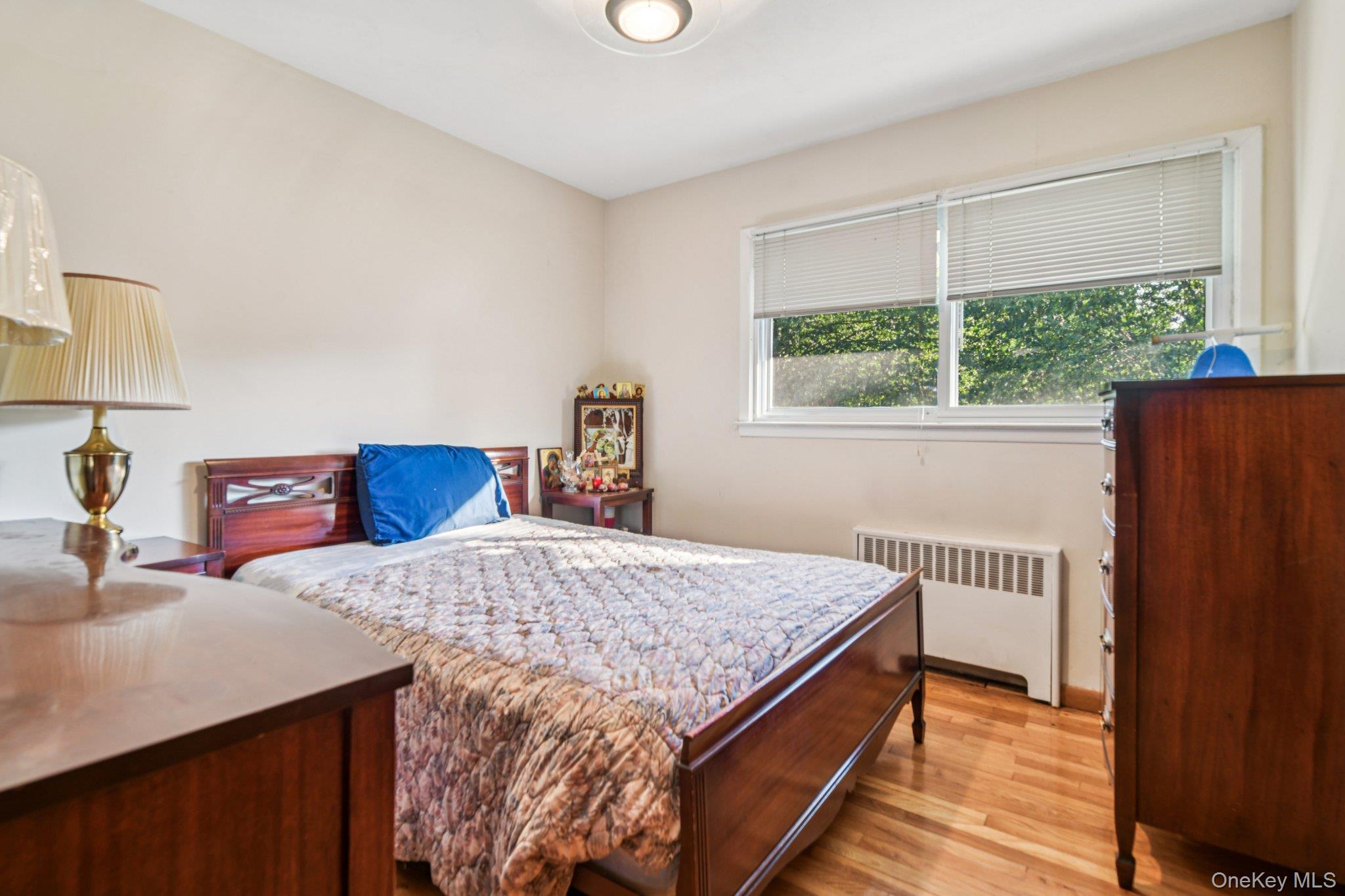 22 Reynolds Road Glen Cove, NY 11542 - Photo 14 of 22 a bed sitting in a bedroom next to a window