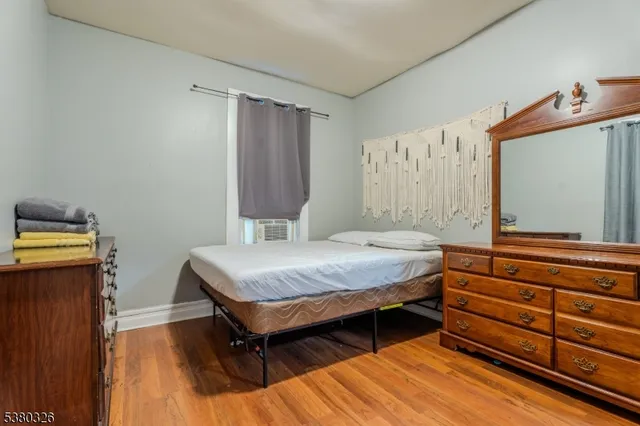 a bedroom with a bed and a flat tv screen on dresser