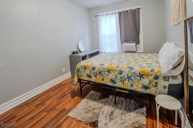 a bed sitting in a bedroom next to a window with chair