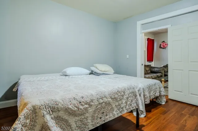 a bedroom with a bed and wooden floor