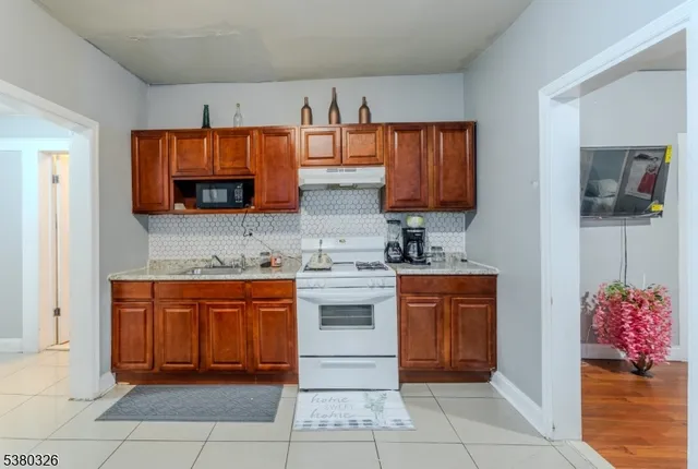 a kitchen with stainless steel appliances granite countertop a stove top oven microwave and cabinets