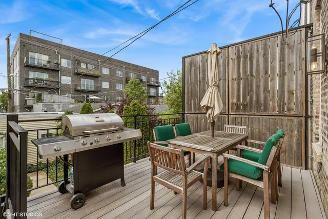 a view of a patio with table and chairs with wooden floor and fence