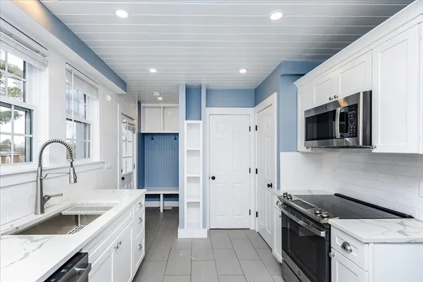 a kitchen with stainless steel appliances granite countertop a stove a sink dishwasher and a refrigerator