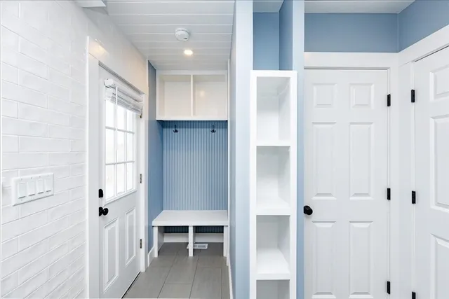 a view of a hallway with wooden floor and windows
