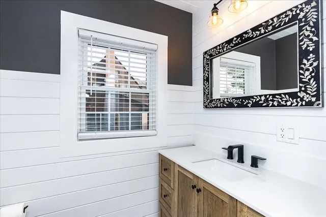 a bathroom with a sink vanity and a mirror