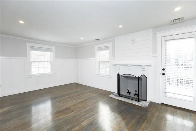 an empty room with wooden floor and fireplace