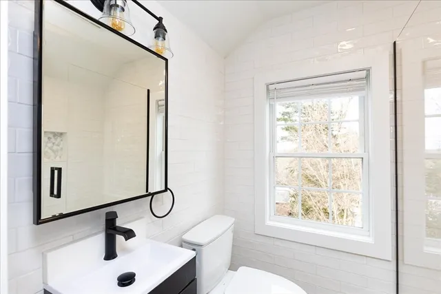 a bathroom with a sink mirror vanity and toilet